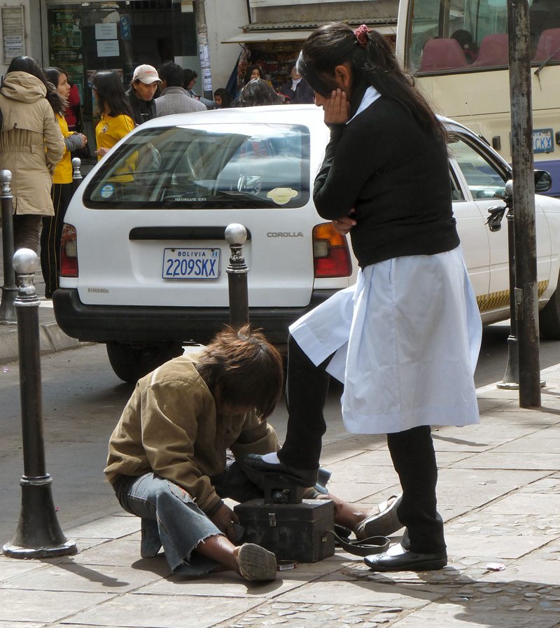 13 heures, sortie des classes. Les enfants de la bourgeoisie locale issus de collèges privés aux uniformes distinctifs se font cirer les chaussures par d'autres enfants, véritables gamins des rues pour qui l'école semble être inaccessible (la scolarité est pourtant obligatoire jusqu'à 16 ans) 